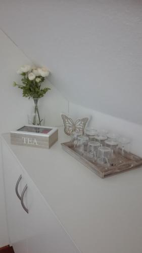 a shelf with a vase of flowers and a butterfly at Pension Mien Fründt in Baabe