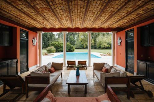 a living room with a couch and a table and a pool at Estancia La Bandada in San Miguel del Monte