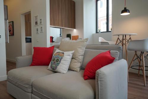 ein Wohnzimmer mit einem Sofa und roten Kissen in der Unterkunft Marquês Modern Art apartment in Lissabon