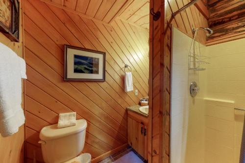 a bathroom with a toilet and a sink and a shower at Bear Hollow Cabin in Tacoma