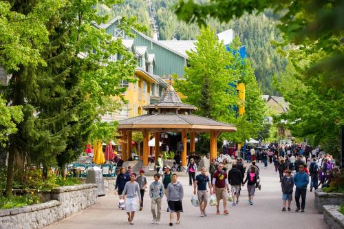 a crowd of people walking down a street in a town at Whistler Town Plaza by Latour Hotels and Resorts in Whistler