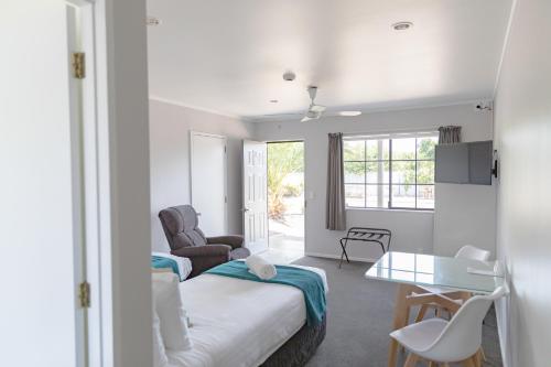 um quarto de hotel com uma cama e uma mesa em BKs Palm Court Motor Lodge em Gisborne