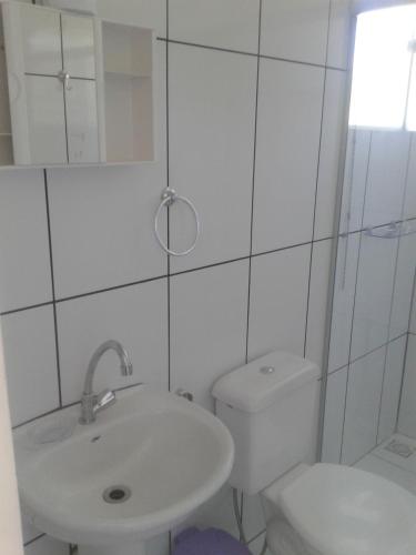 a white bathroom with a sink and a toilet at Pousada Colonetti in Lindóia