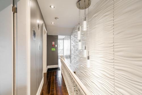 a hallway with a staircase with wood floors and a wall at NB Urban Luxury Suites in Toronto