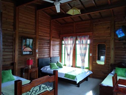 a bedroom with two beds and a tv in it at Horizonte del Quindío - Chalet privado in Quimbaya