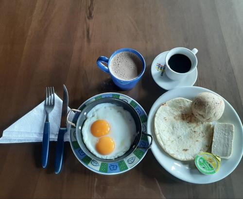 a breakfast of eggs and bread and coffee on a table at Horizonte del Quindío - Chalet privado in Quimbaya