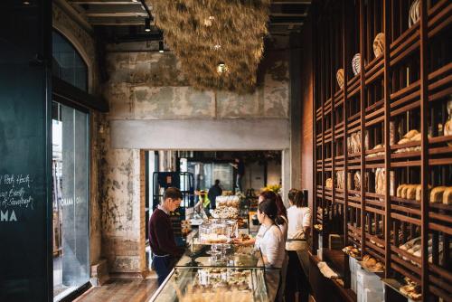 a group of people standing at a counter in a bakery at The Hotel Britomart in Auckland