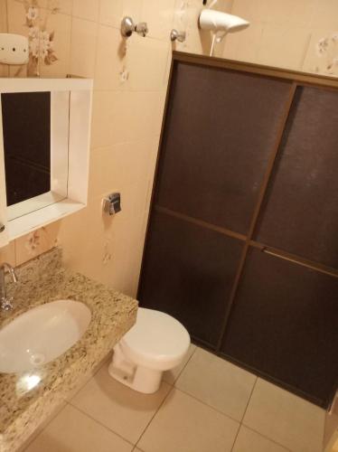 a bathroom with a toilet and a sink and a shower at Hostel Wanderlust in Foz do Iguaçu