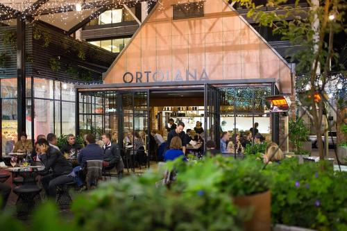 a group of people sitting at tables in a restaurant at The Hotel Britomart in Auckland