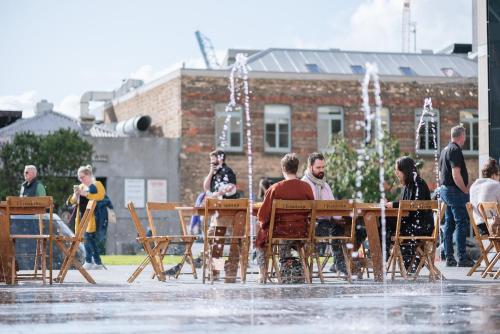 a group of people sitting at a table in front of a fountain at The Hotel Britomart in Auckland