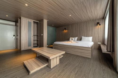 a bedroom with a bed and a bench and a table at Kontena Hotel in Batu