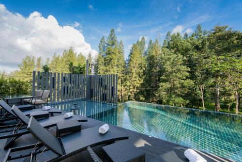 una piscina con mesa y sillas en un patio en Hill Myna Condotel, en Bang Tao Beach