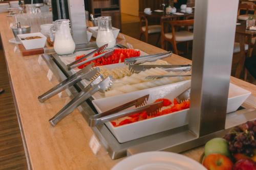 リオデジャネイロにあるSquare Design Hotelのレストランのテーブルに並べられたビュッフェ形式の料理