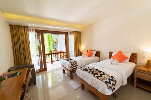 ein Hotelzimmer mit 2 Betten und einem Balkon in der Unterkunft Komodo Lodge in Labuan Bajo