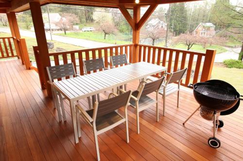 una parrilla en una terraza con mesa y sillas en Cottage All Resort Service / Vacation STAY 8450 en Inawashiro