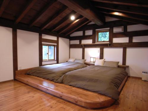 een groot bed in een kamer met houten vloeren bij Cottage All Resort Service / Vacation STAY 8448 in Inawashiro