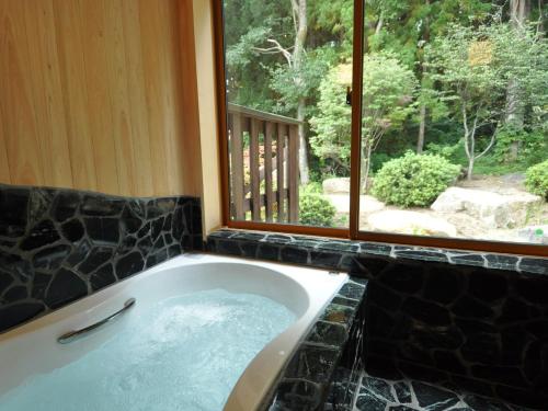 y baño con bañera y ventana. en Cottage All Resort Service / Vacation STAY 8448, en Inawashiro