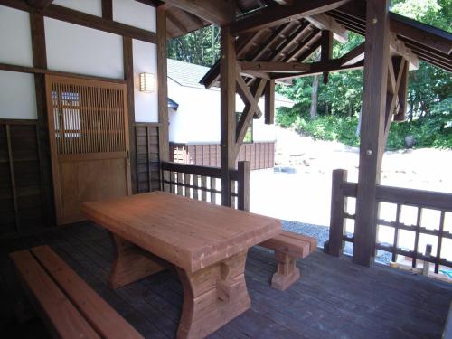 una panchina di legno seduta sul portico di un edificio di Cottage All Resort Service / Vacation STAY 8448 a Inawashiro