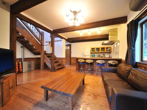 ein Wohnzimmer mit einem Sofa und einem Tisch in der Unterkunft Cottage All Resort Service / Vacation STAY 8445 in Inawashiro