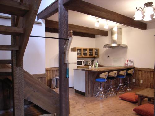 eine Küche mit einer Theke und Hockern in einem Zimmer in der Unterkunft Cottage All Resort Service / Vacation STAY 8445 in Inawashiro