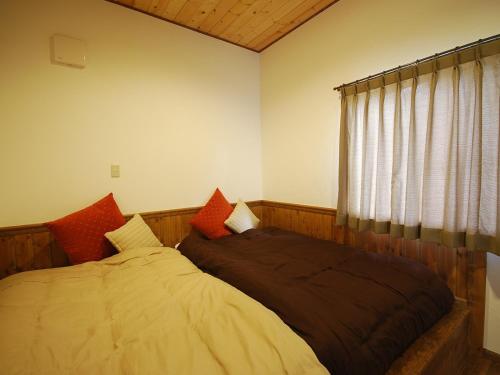 Schlafzimmer mit einem Bett und einem Fenster in der Unterkunft Cottage All Resort Service / Vacation STAY 8445 in Inawashiro