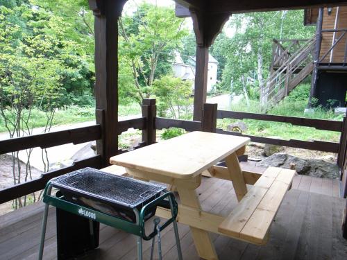 einen Picknicktisch auf der Veranda eines Hauses in der Unterkunft Cottage All Resort Service / Vacation STAY 8445 in Inawashiro