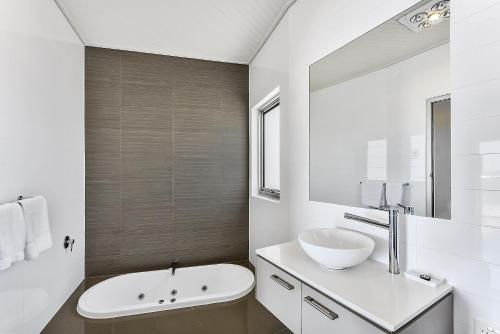 a white bathroom with a sink and a mirror at Aloha Highview in Robe