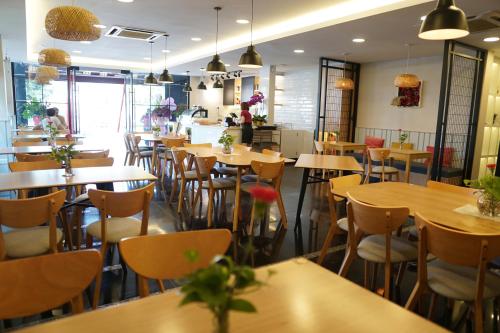 a restaurant with tables and chairs in a room at Mangga Boutique Hotel in Seri Kembangan