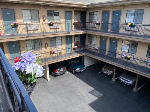 an apartment building with cars parked in a parking lot at Westwind Lodge in Oakland