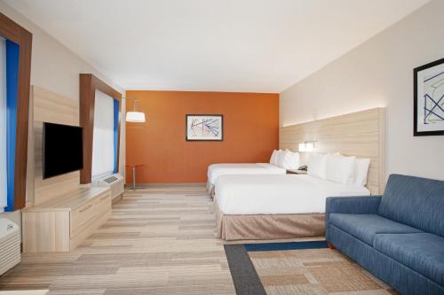 a hotel room with a bed and a couch at Holiday Inn Express & Suites Phoenix Glendale Dist by IHG in Glendale