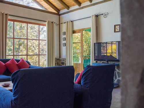 a living room with two blue couches and a tv at Casa de Lujo La Campana in Olmué