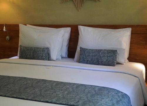 a bed with two pillows and a head board at Arana Suite in Legian