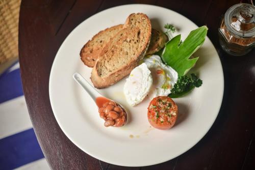 einen Teller mit Brot und Gemüse auf dem Tisch in der Unterkunft Bali Mystique Hotel & Apartment in Seminyak