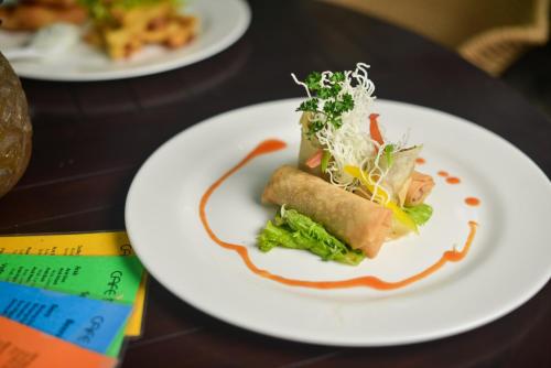 ein weißer Teller mit Lebensmitteln auf einem Tisch in der Unterkunft Bali Mystique Hotel & Apartment in Seminyak