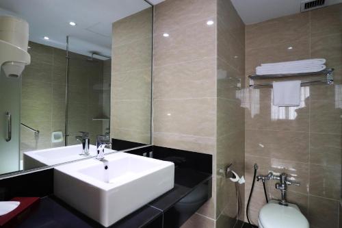 a bathroom with a white sink and a mirror at Hotel Grand Continental Kuala Lumpur in Kuala Lumpur