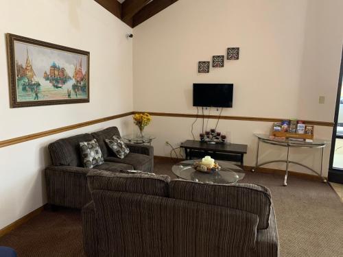 Una sala de estar con dos sofás y un televisor. en Owensville Inn, en Owensville