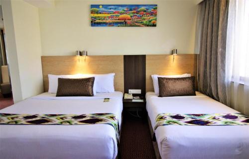 a hotel room with two beds in a room at Hotel Grand Continental Kuala Lumpur in Kuala Lumpur