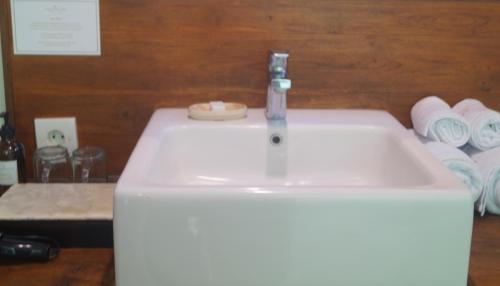 a white sink with a faucet on top of it at Arana Suite in Legian