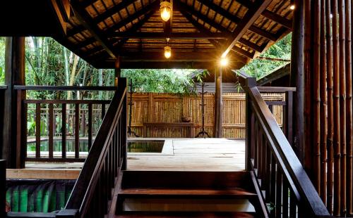 a wooden stairs leading to a porch with a wooden fence at คุ้มสะเมิง-Samoeng Center in Samoeng