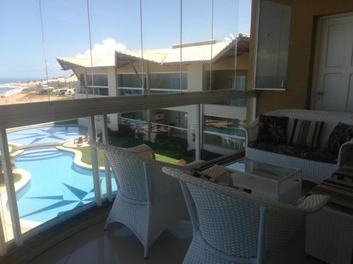 a balcony with chairs and a view of a building at EmanuelleSales - Corretora de Imóveis - "LUXURY RESIDENCES" creci 16949F in Canoa Quebrada
