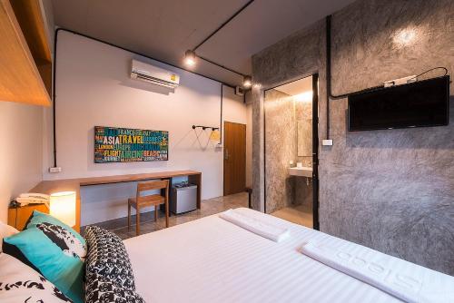 Habitación con cama y escritorio. en Sleep Hotel - SHA Certified, en Suratthani