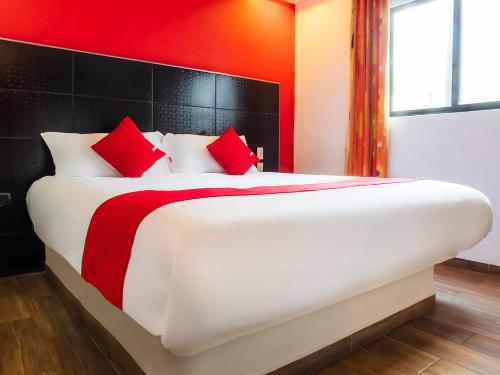 a bedroom with a large white bed with red pillows at Hotel SR92 Adults Only in Mexico City