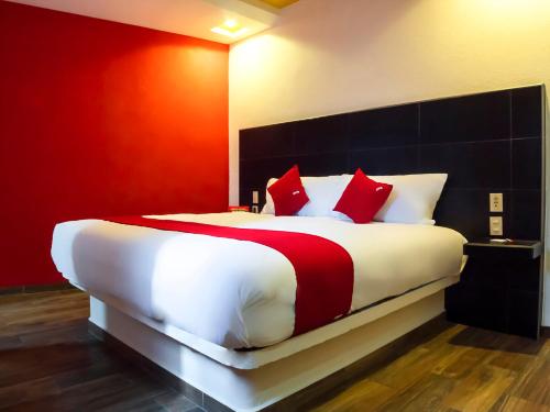 a bedroom with a large white bed with red pillows at Hotel SR92 Adults Only in Mexico City