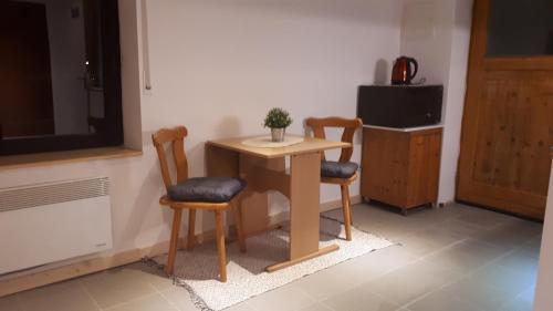 una mesa pequeña y 2 sillas en una habitación en Fewo Be Happy! Kleiner Bungalow mit eigener Terrasse im Grünen! en Stockhausen-Illfurth