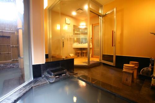 uma casa de banho com um chuveiro e uma piscina de água em Takinoya Bekkan Tamanoyu em Noboribetsu