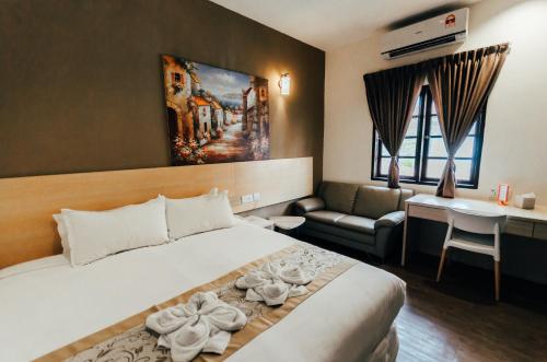 ケルテにあるKertih Damansara Innのベッドとソファ付きのホテルルーム