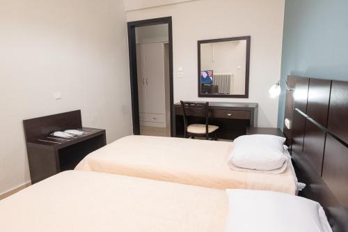 a room with two beds and a desk and a mirror at Democritus in Komotini