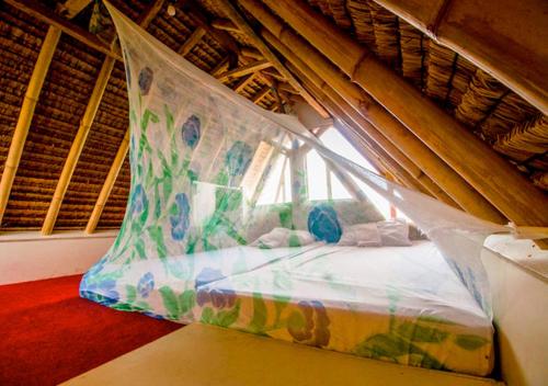 un letto a baldacchino in una stanza con finestra di The Rabbit Tree Hostel a Gili Meno