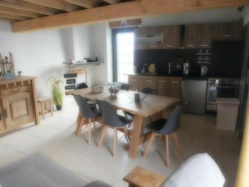 a kitchen with a wooden table and chairs at La cabane du chasseur in Flines-lès-Mortagne