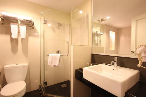 y baño con aseo, lavabo y ducha. en Harmoni One Convention Hotel and Service Apartments, en Batam Centre